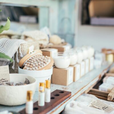 Many fragrant candles placed near massage brushes and perfume in shop for sale